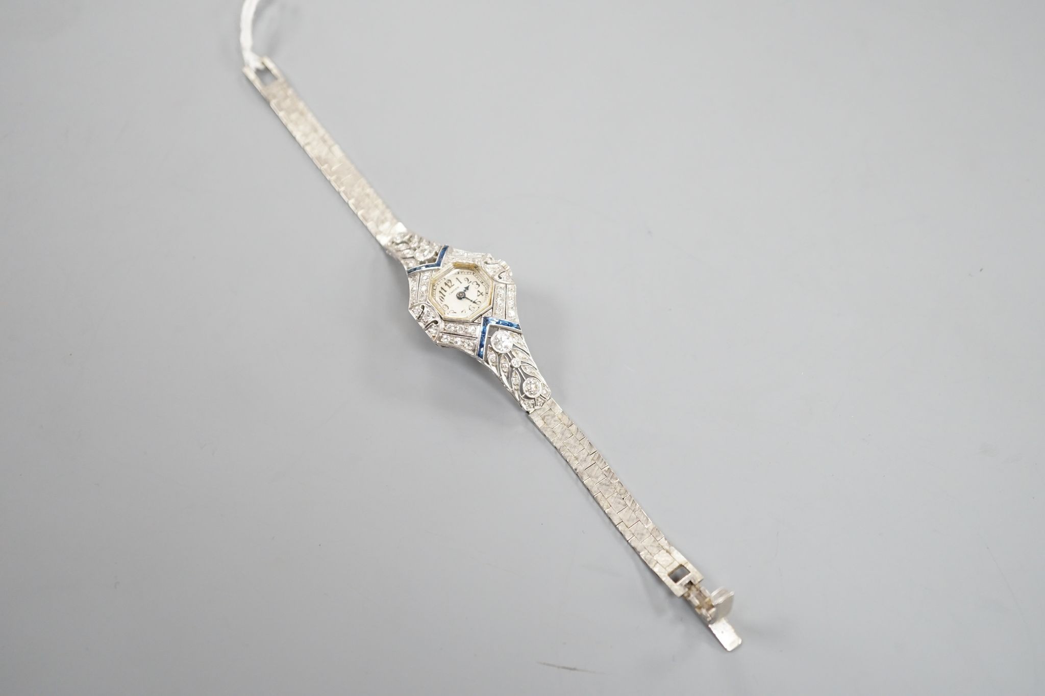 A mid 20th century white metal, synthetic sapphire? and diamond set cocktail watch, with Bucherer manual wind movement and dial bearing the signature Cartier, on a 14k white metal bracelet, case diameter 22mm, gross weig